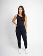 Mulher usando legging modeladora preta de cintura alta, fundo branco, moda fitness.