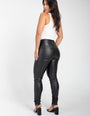 Mulher usando calça modeladora preta de cintura alta e regata branca, vista de costas.
