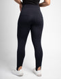 Calça modeladora preta de cintura alta, vista traseira, com bolsos e recorte nos tornozelos.