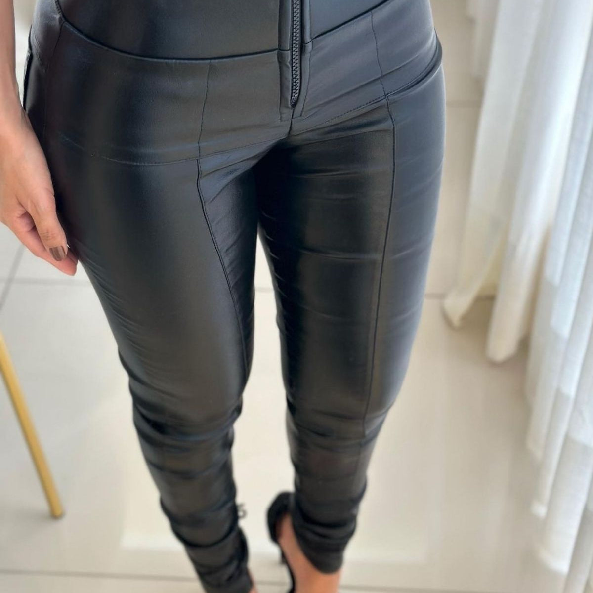 Calça modeladora preta feminina de cintura alta, com zíper frontal, tecido ajustado ao corpo.